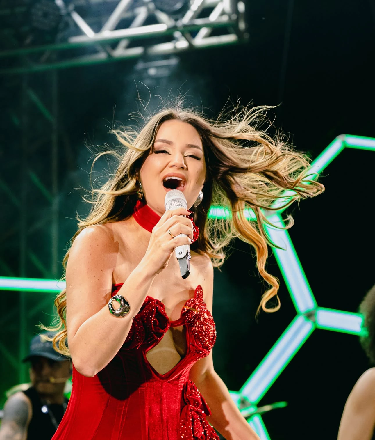 Cantora em show com hexágonos de LED ao fundo